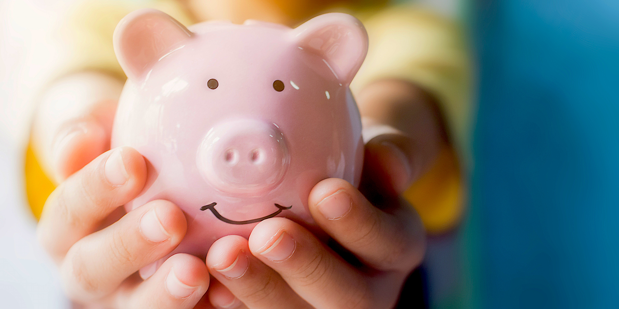 Hands holding a piggy bank.