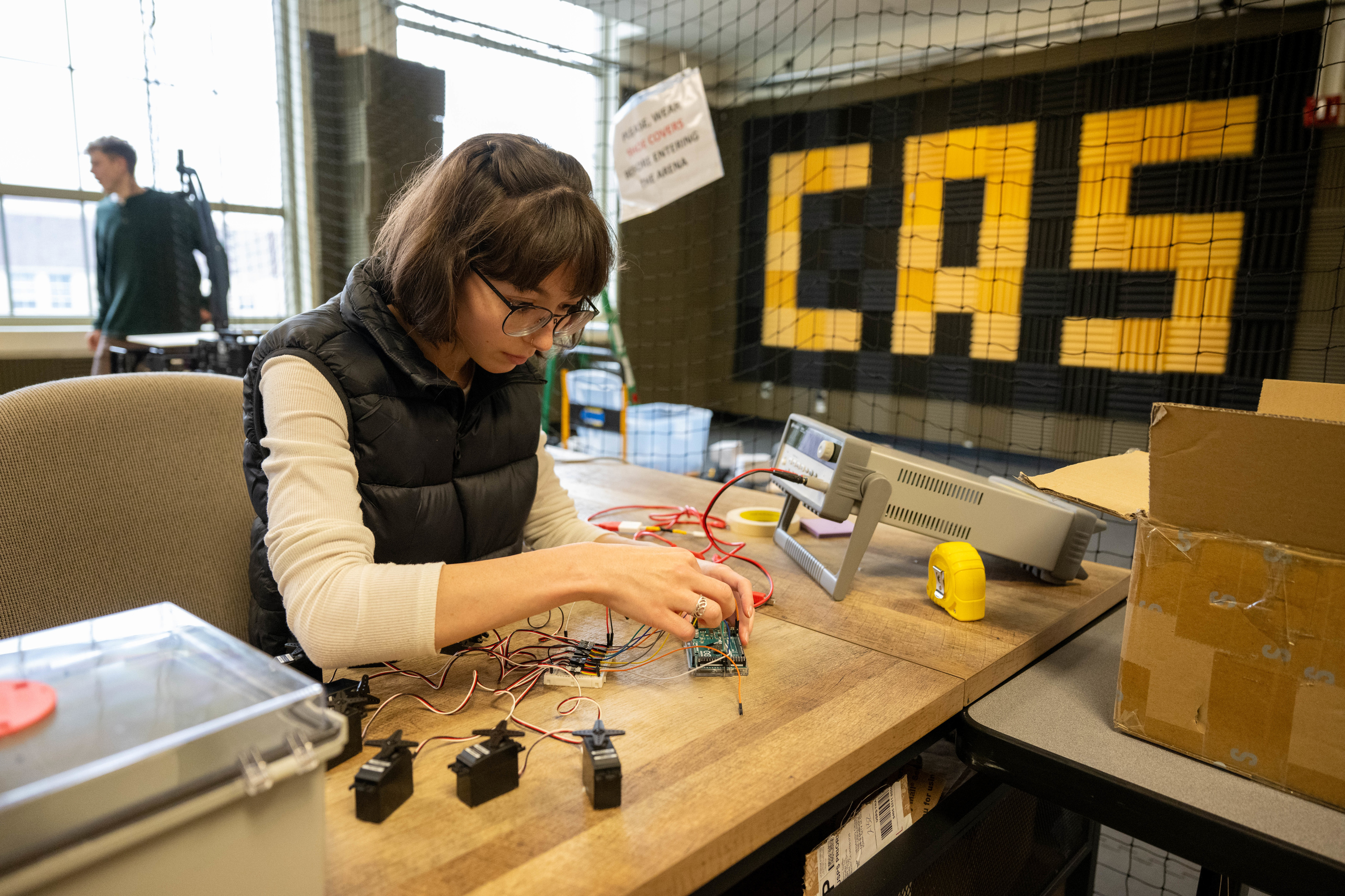 A woman works in the Cooperative Autonomous Systems Lab within the College of Engineering.