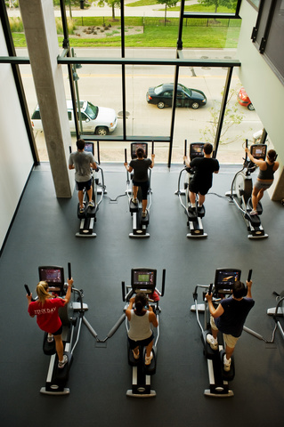 people in gym on cardio machines
