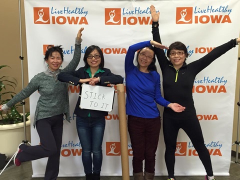 4 women strike a pose in front of live Healthy Iowa photo booth