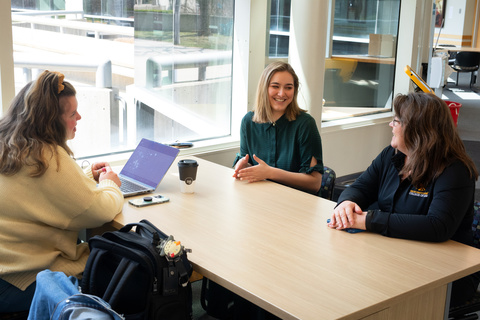 3 employees talking and smiling