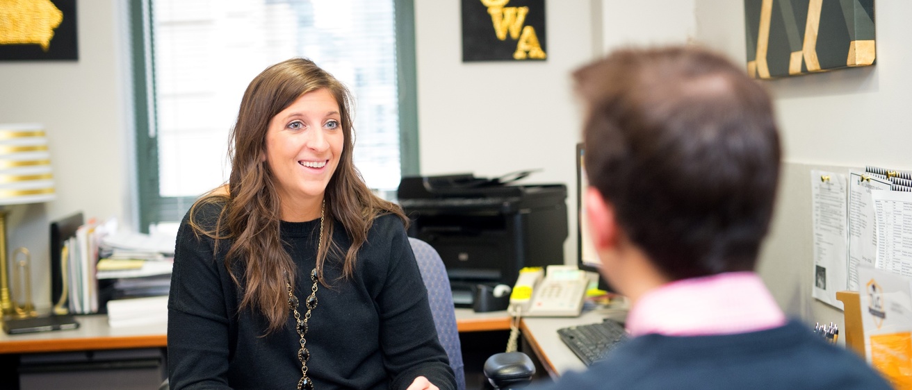 Two University of Iowa employees have a conversation in an office