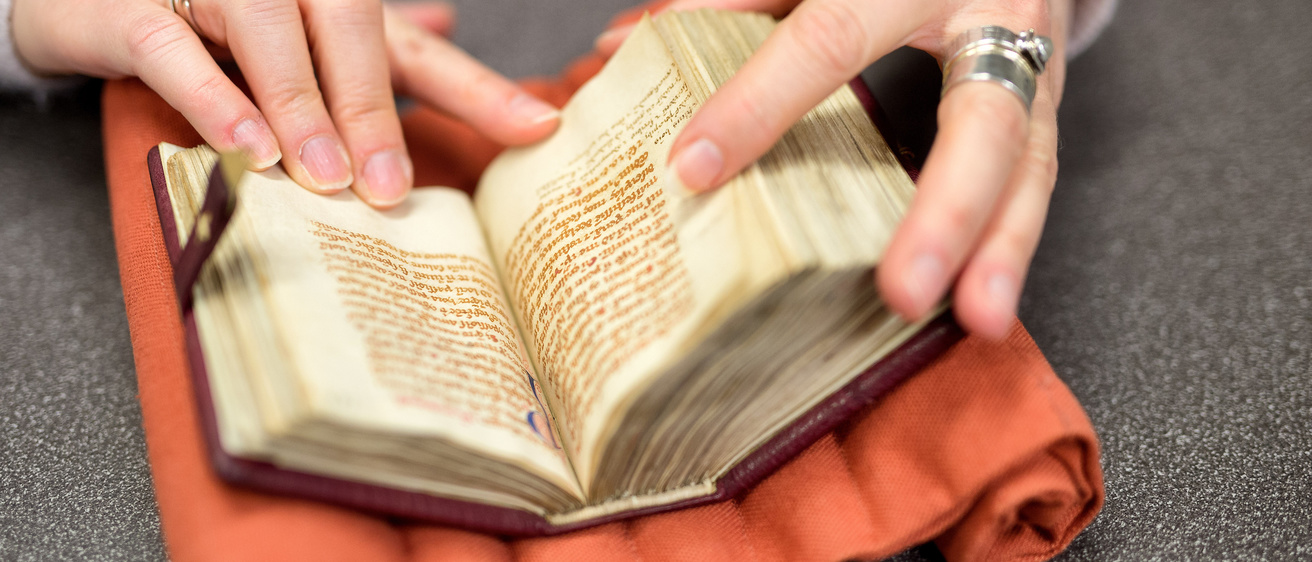 Hands flip through a small book
