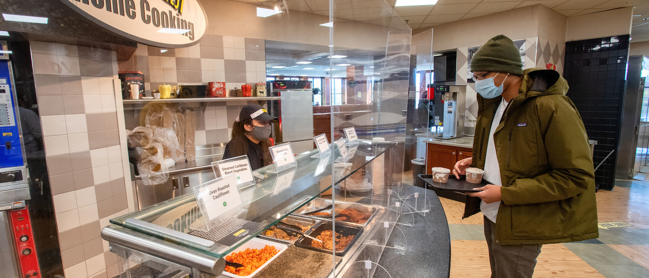A student gets food from Golden Harvest Home Cooking at Hillcrest Marketplace