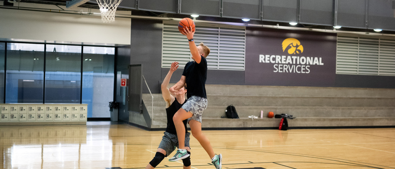 Two people playing basketball at the Campus Recreation and Wellness Center