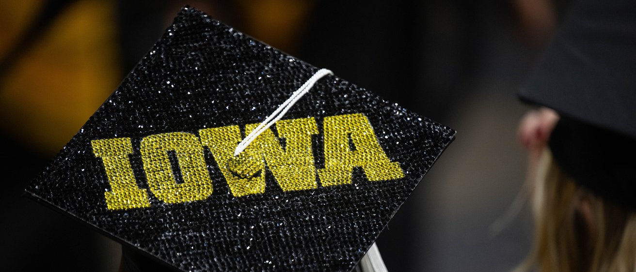 Graduation cap that reads Iowa in bold gold letters