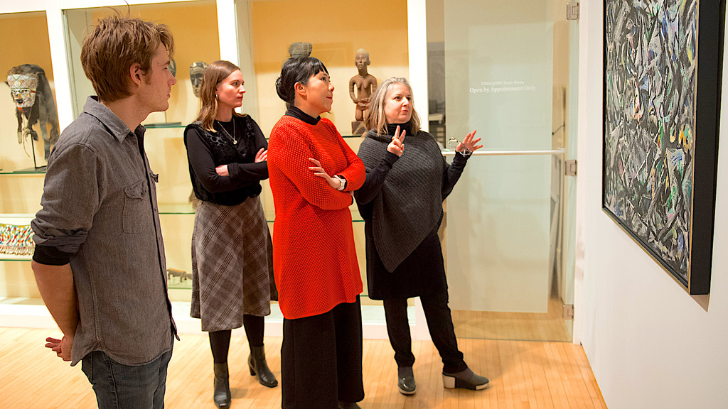 People talking about a painting in a gallery.