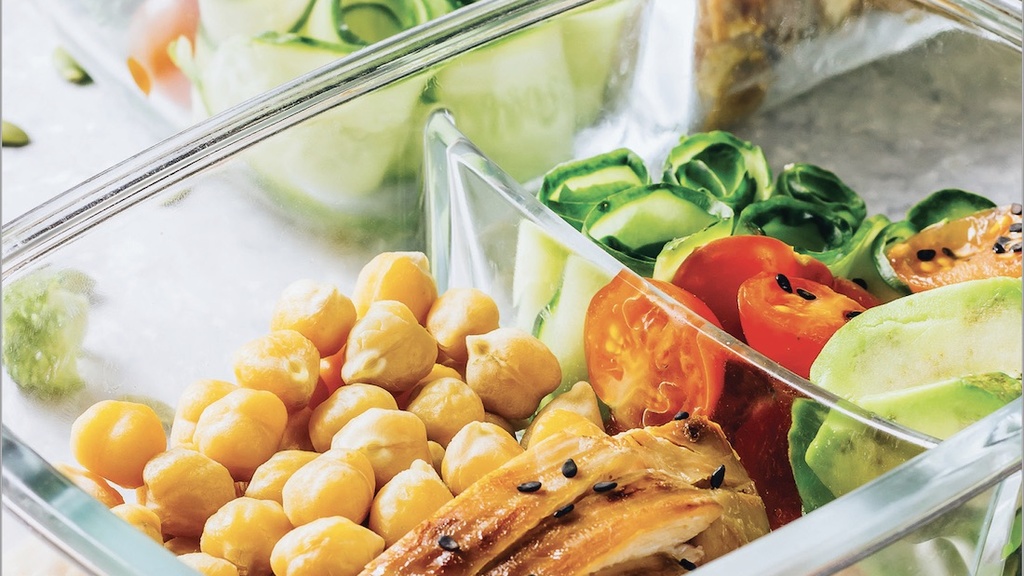 Chickpeas, chicken, and vegetables in a glass storage container.