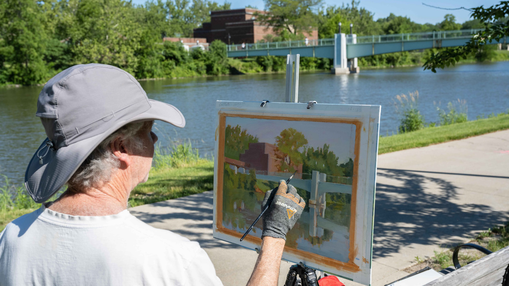 man painting a picture of the art building on University of Iowa campus.