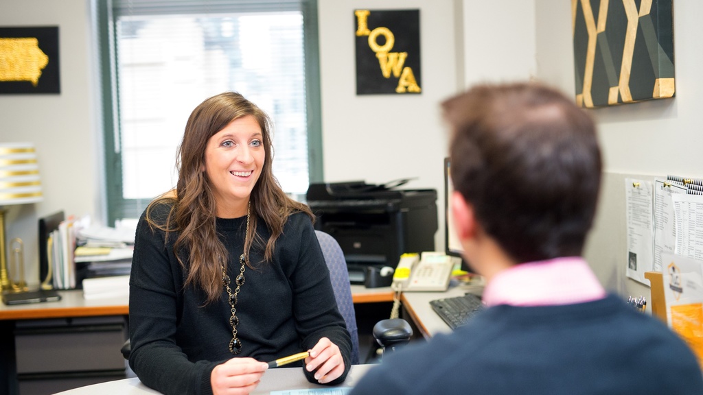 Two University of Iowa employees have a conversation in an office