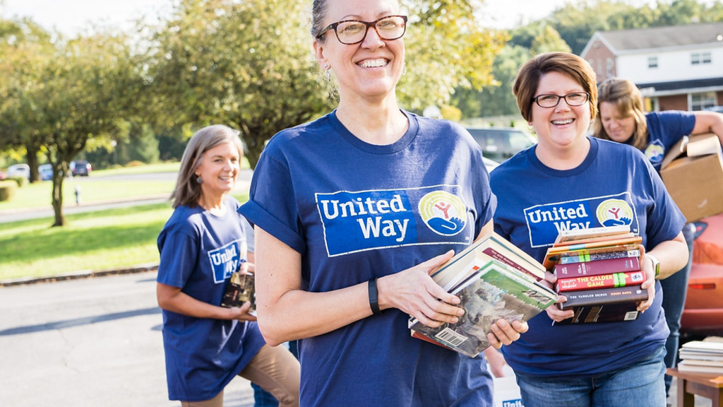 United Way volunteers carrying books outside