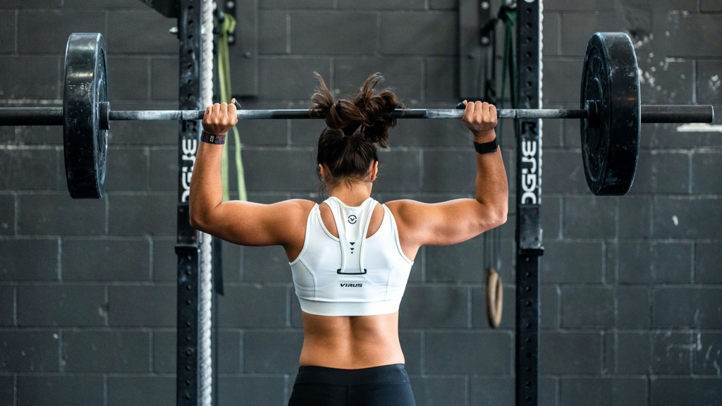 woman holding barbell above head