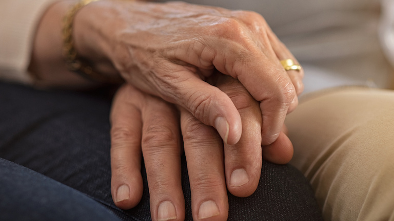 Clasped pair of older adult hands.
